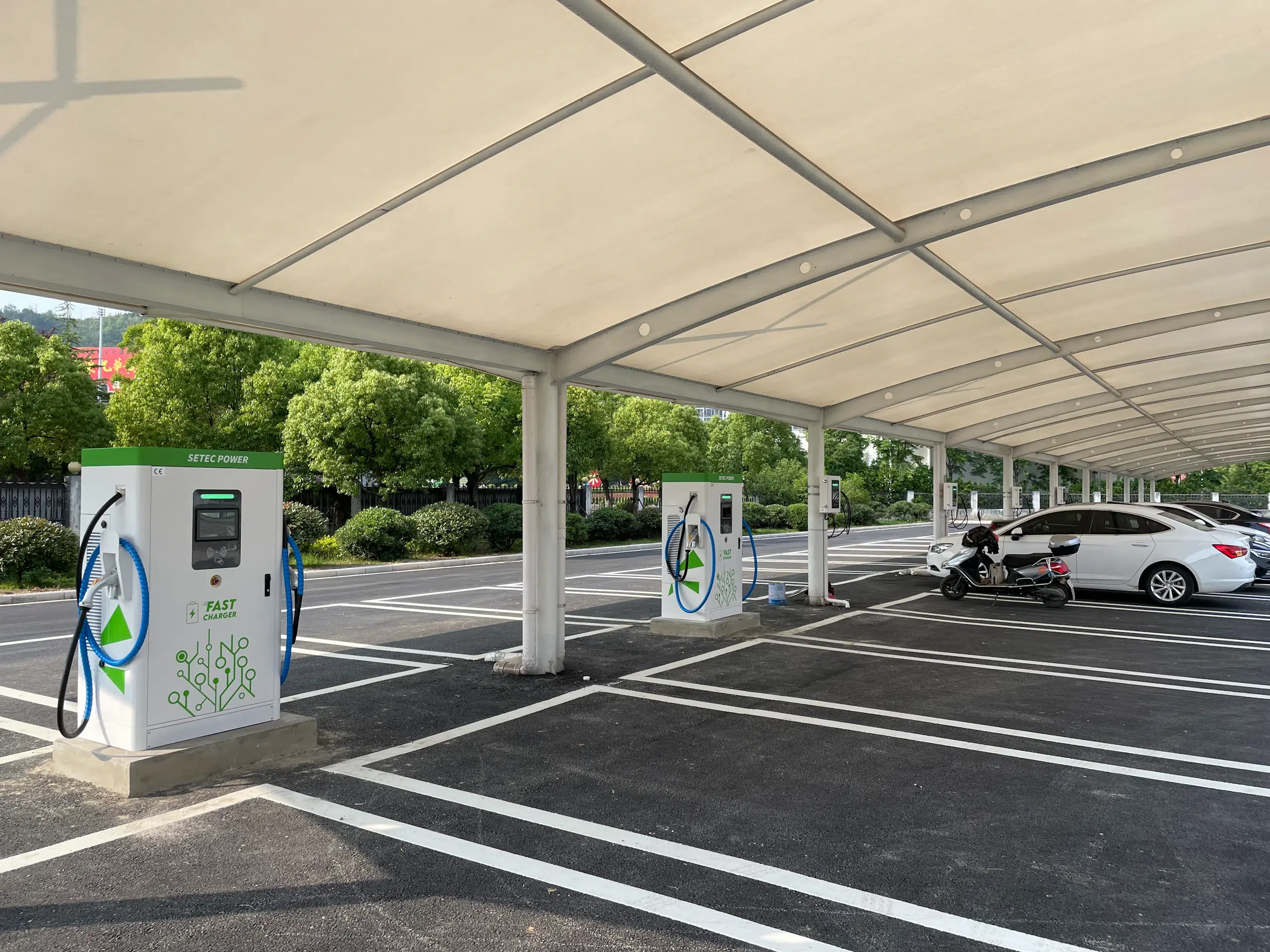 Smart EV charging stations with canopy integration in hospitality business parking, showcasing clean energy infrastructure and commercial destination chargers by SETEC POWER.