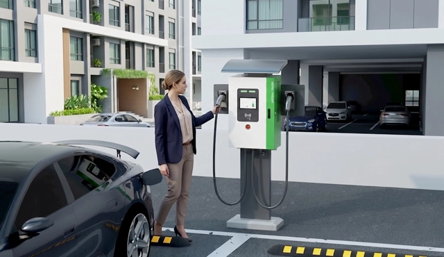 Woman charging an electric vehicle with a home EV charging station in a residential garage